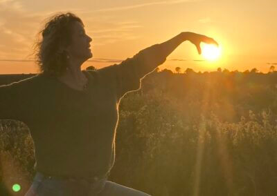 a woman standing in front of the sun